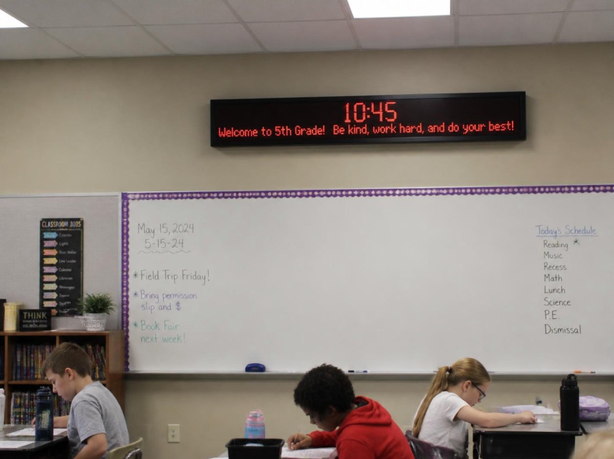 LED message display and clock above a whiteboard